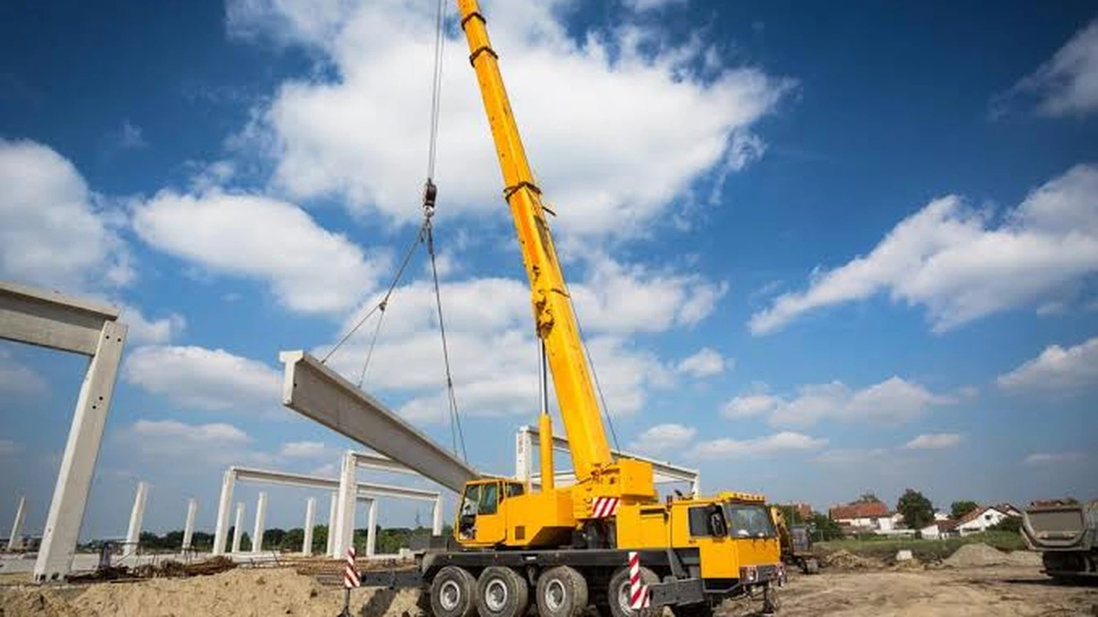 Real mobile crane lifting a structural beam on a construction site.