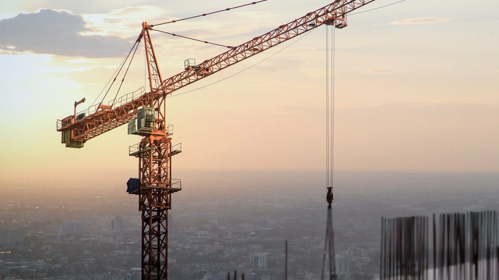 Real tower crane on a high-rise construction site at sunset